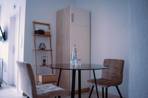 - une table à manger avec 2 chaises et une bouteille dans l'établissement Modernes Apartment in der Altstadt , kostenlose Parkplätze in der Nähe, à Emden