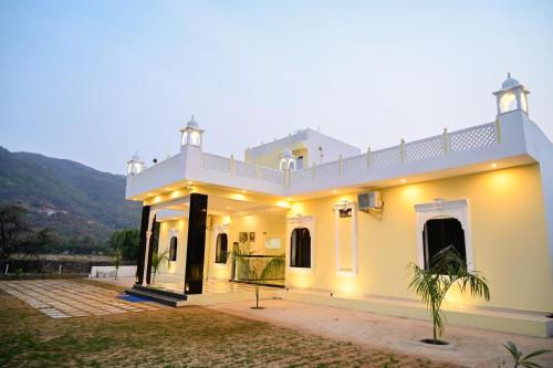 una gran casa blanca con una colina en el fondo en The Ashok Heritage Resort & Retreat, en Pushkar