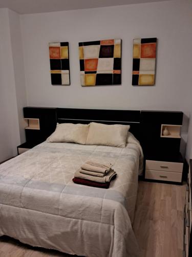 a bedroom with a bed with four paintings on the wall at Centrico, Parking incluido in Jaén
