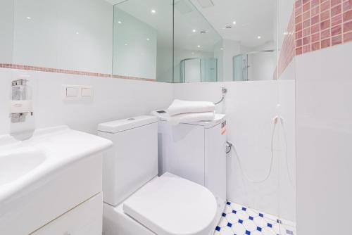 a white bathroom with a toilet and a shower at Yoga Residence Apartments in Tallinn