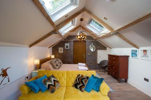 a bedroom with a yellow bed and a yellow couch at The Tullet, boutique hideaway in Somerset in Banwell