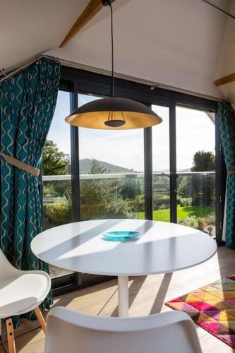 a white table and chairs in a room with a window at The Tullet, boutique hideaway in Somerset in Banwell