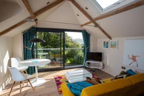 a living room with a yellow couch and a table at The Tullet, boutique hideaway in Somerset in Banwell