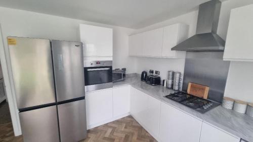 a kitchen with white cabinets and a stainless steel refrigerator at Penton place in Catterall