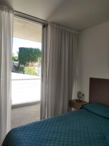 a bedroom with a bed and a large window at HERMOSO DEPARTAMENTO EN EL CENTRO DE ROSARIO in Rosario