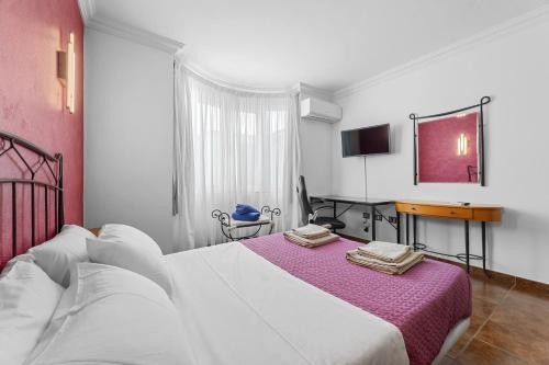 um quarto com uma cama, uma secretária e uma televisão em Villa Portugal - Villasexperience em Tahiche