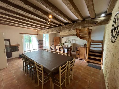 une grande salle à manger avec une table et des chaises dans l'établissement La Closerie de la Hérissière, à La Jaille-Yvon