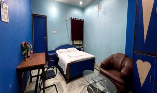 een kamer met een bed, een tafel en een stoel bij FabHotel LB Imperia in Muzaffarpur