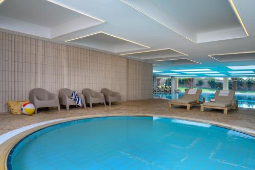 a pool in a hotel room with chairs and a swimming pool at Leonardo Plaza Haifa in Haifa