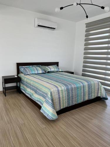 a bedroom with a bed with a striped comforter at Four seasons sea holiday in Iskele