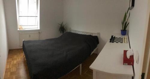 ein Schlafzimmer mit einem Bett mit einer schwarzen Decke in der Unterkunft Cozy appartement in Wien