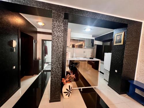 a kitchen with black and white walls and a pillar at Apartament zona fabricii Ford in Craiova