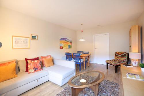 ein Wohnzimmer mit einem Sofa und einem Tisch in der Unterkunft Edinburgh Central 2-Bedroom Old Town Apartment in Edinburgh