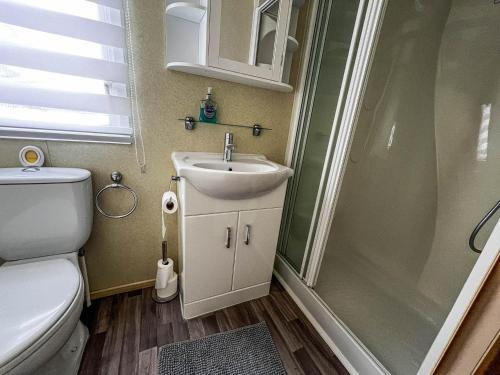 a bathroom with a toilet and a sink and a shower at Wonderful 8 Berth Caravan At Seawick Holiday Park In Clacton-on-sea Ref 27077r in Clacton-on-Sea