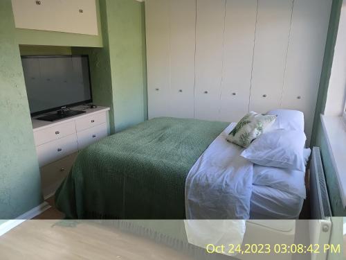 um pequeno quarto com uma cama e uma televisão em Welcome to Bombay House! em Hatfield