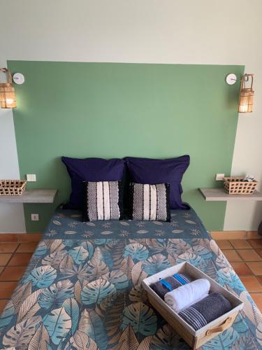 a bedroom with a bed with a tray of towels at Sous les tropiques in La Trinité