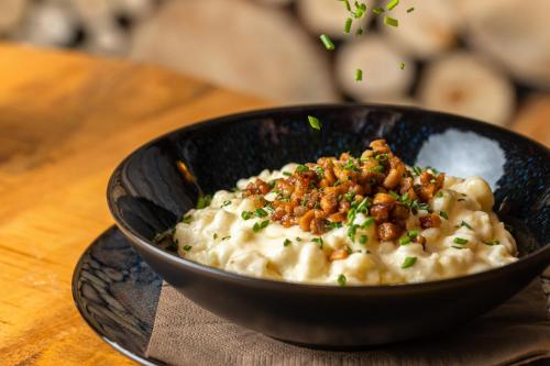 a black bowl of mashed potatoes with nuts on top at Penzion BERG in Bratislava