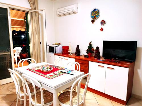 a kitchen and dining room with a white table and chairs at Sea Garden, fronte mare con piscina in Mascali