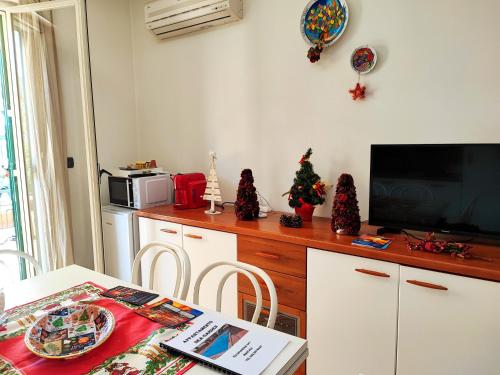 a kitchen with a table with a television and christmas decorations at Sea Garden, fronte mare con piscina in Mascali