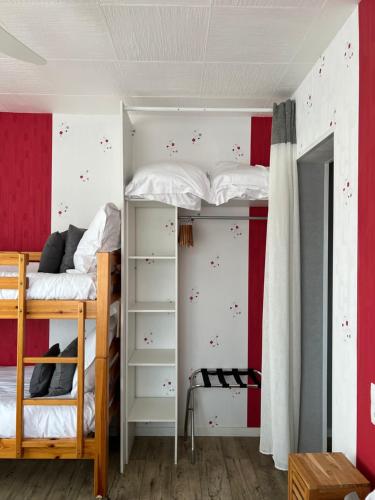 a bedroom with two bunk beds with red and white walls at Au Petit Bonheur in La Tranche-sur-Mer