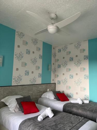 two beds in a bedroom with blue walls and a ceiling at Au Petit Bonheur in La Tranche-sur-Mer