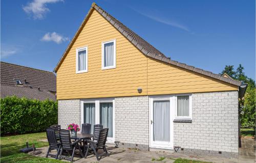 a house with a table and chairs in front of it at Oesterbaai 8 Personen in Wemeldinge