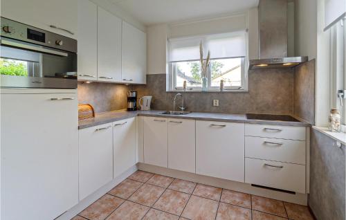 a kitchen with white cabinets and a sink at Oesterbaai 8 Personen in Wemeldinge