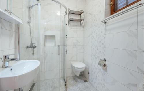 Baño blanco con aseo y lavamanos en Nice Apartment In Herceg Novi With 1 Bedrooms, Wifi And Outdoor Swimming Pool en Herceg-Novi