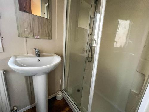 a bathroom with a sink and a shower at Great 10 Berth Caravan At Martello Beach Holiday Park Ref 29045dw in Clacton-on-Sea