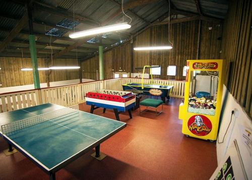 a room with two tables and a game room with at Meadow Lakes Holiday Park in St Austell