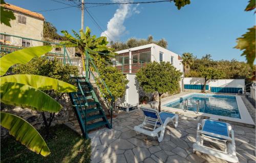 a pool with two chairs and a ladder next to a house at Beautiful Apartment In Herceg Novi With 1 Bedrooms, Wifi And Outdoor Swimming Pool in Herceg-Novi