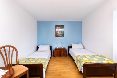 2 letti in una camera con pareti blu di Apartment Petar a Poljica