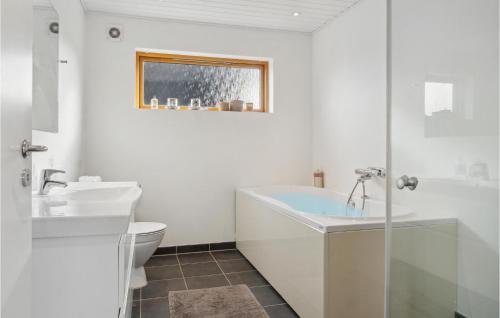 a white bathroom with a tub and a toilet at Gorgeous Home In Stubbekbing With Kitchen in Stubbekøbing