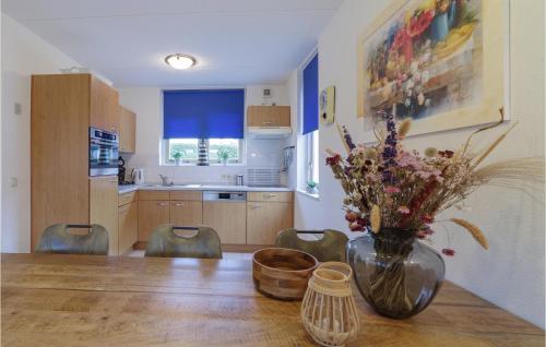 a kitchen with a table with a vase of flowers on it at 4 Bedroom Gorgeous Home In Wemeldinge in Wemeldinge