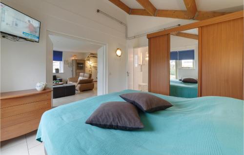 a bedroom with a blue bed with two pillows at 4 Bedroom Gorgeous Home In Wemeldinge in Wemeldinge