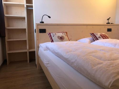 a bedroom with two beds and a book shelf at B&B Tilde in Tesero