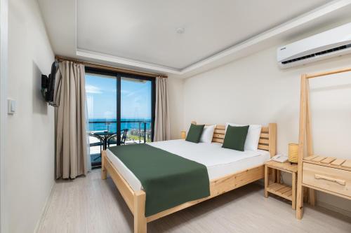 sypialnia z łóżkiem i widokiem na ocean w obiekcie Feniks Otel w mieście Okurcalar