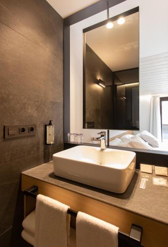 a bathroom with a sink and a large mirror at Hotel Cortabitarte in Soria