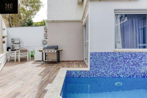 a house with a swimming pool and a table at A lovely 4BR home with private POOL & BBQ by 360 Estates in Is-Swieqi