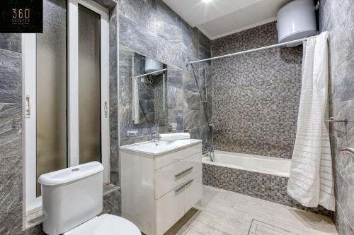 a bathroom with a toilet and a sink and a tub at A lovely 4BR home with private POOL & BBQ by 360 Estates in Is-Swieqi