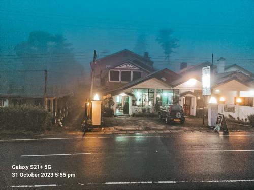 una casa en una calle por la noche con luces en Cool Feel Rest, en Nuwara Eliya