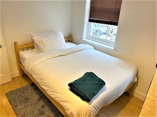 a bed with a green pillow on it in a bedroom at Smart 1 Bedroom Apartment in the City - Islington in London
