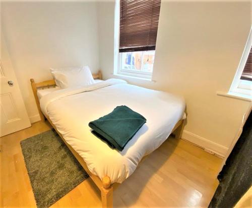 a bedroom with a bed with a green towel on it at Smart 1 Bedroom Apartment in the City - Islington in London