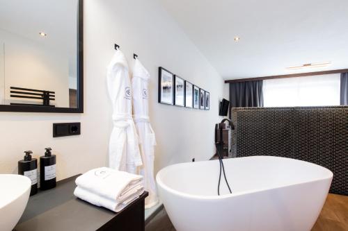 a white bathroom with a tub and a sink at Dorfchalet das Luxus-Wellness-Chalet im Skigebiet in Grossarl
