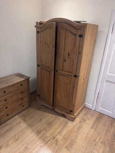 a wooden cabinet and a dresser in a room at 10 Cornwell Avenue in Kent