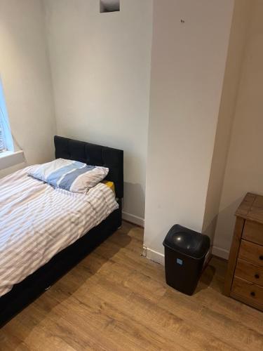 a bedroom with a bed and a trash can at 10 Cornwell Avenue in Kent