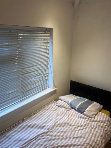 a small bedroom with a bed and a window at 10 Cornwell Avenue in Kent