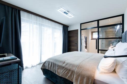 a bedroom with a large bed and a window at Dorfchalet das Luxus-Wellness-Chalet im Skigebiet in Grossarl
