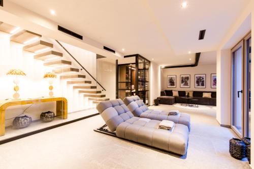 a living room with a couch and a staircase at Dorfchalet das Luxus-Wellness-Chalet im Skigebiet in Grossarl