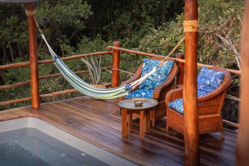 a porch with two chairs and a hammock at Chole Mjini Treehouses Lodge in Utende